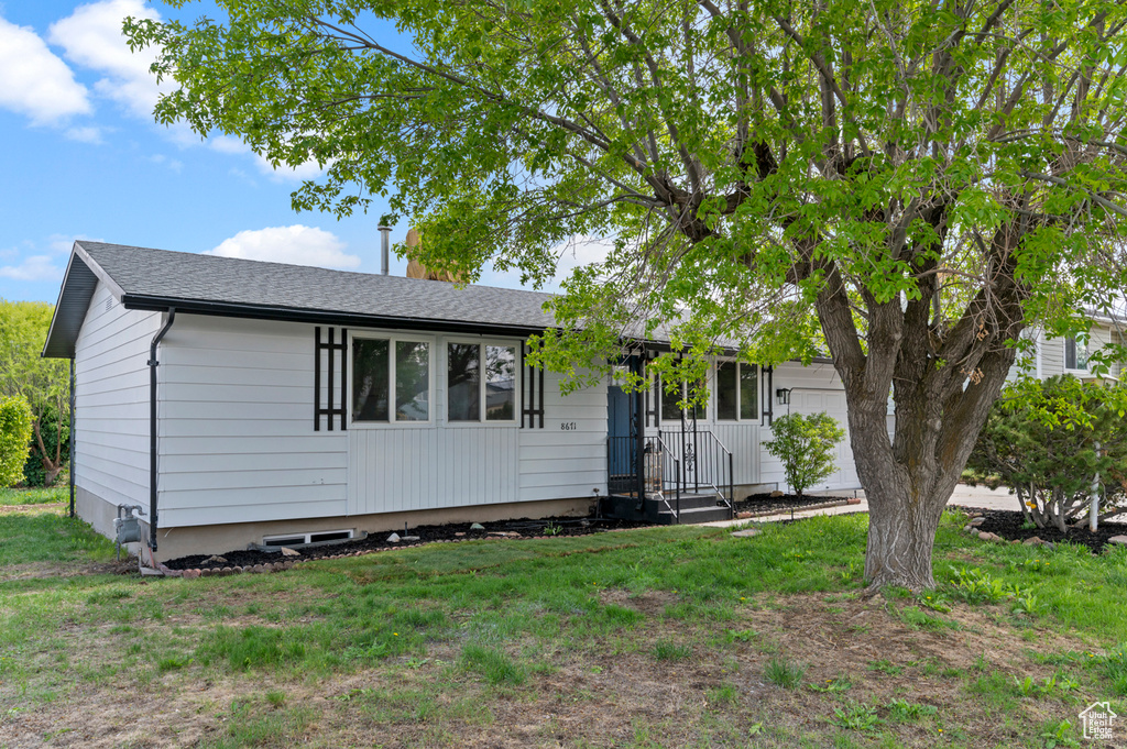 Ranch-style home with a garage and a front lawn
