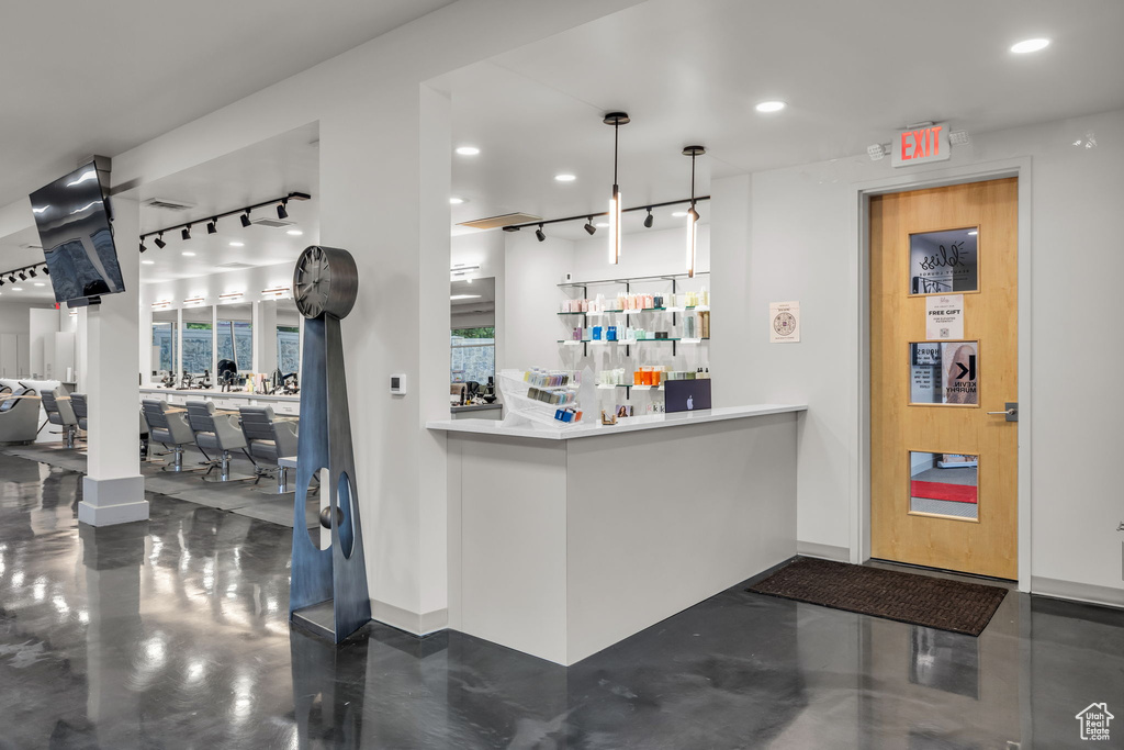 Bar featuring decorative light fixtures, recessed lighting, baseboards, and finished concrete flooring