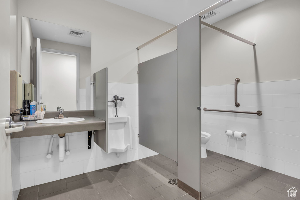 Bathroom with visible vents, wainscoting, a shower, a sink, and toilet
