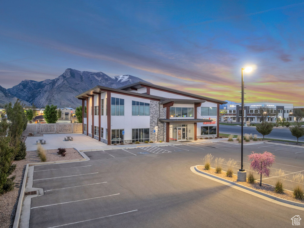 Exterior space featuring uncovered parking, fence, and a mountain view