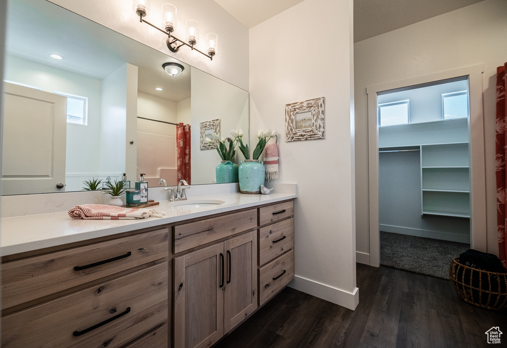 Bathroom featuring vanity, baseboards, and wood finished floors