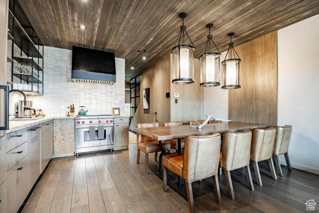 Kitchen featuring luxury range, extractor fan, dark wood-type flooring, wood ceiling, and a sink