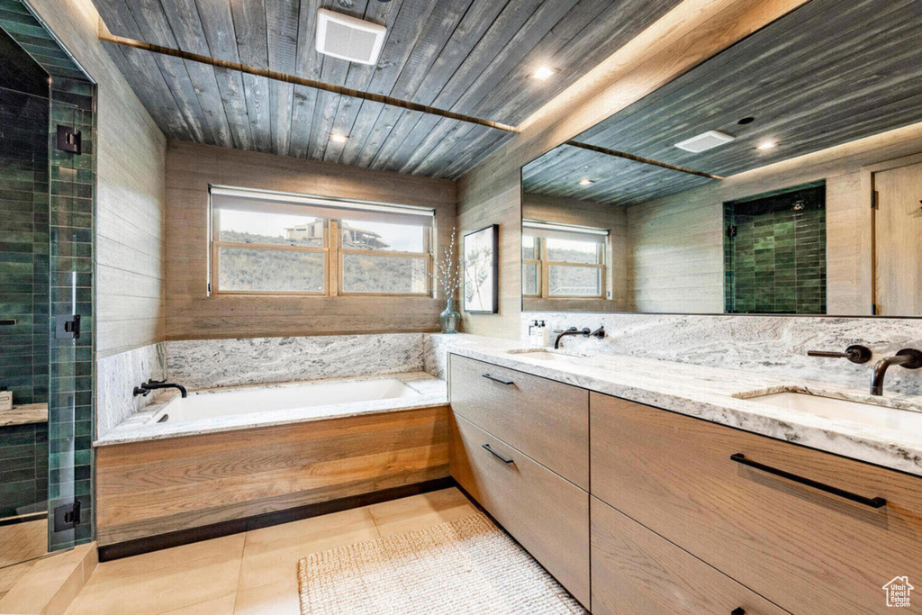 Bathroom with a sink, double vanity, a stall shower, and a garden tub
