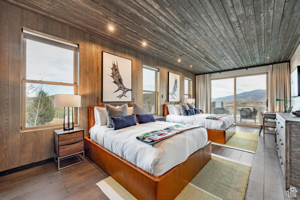 Bedroom featuring wood ceiling, multiple windows, wood-type flooring, and access to exterior