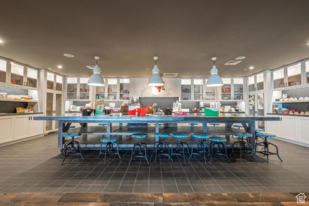 Bar with dark tile patterned flooring, recessed lighting, decorative light fixtures, and visible vents