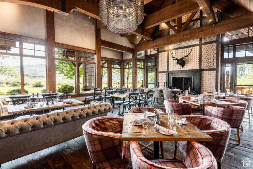 Dining space with beamed ceiling, high vaulted ceiling, and hardwood / wood-style floors