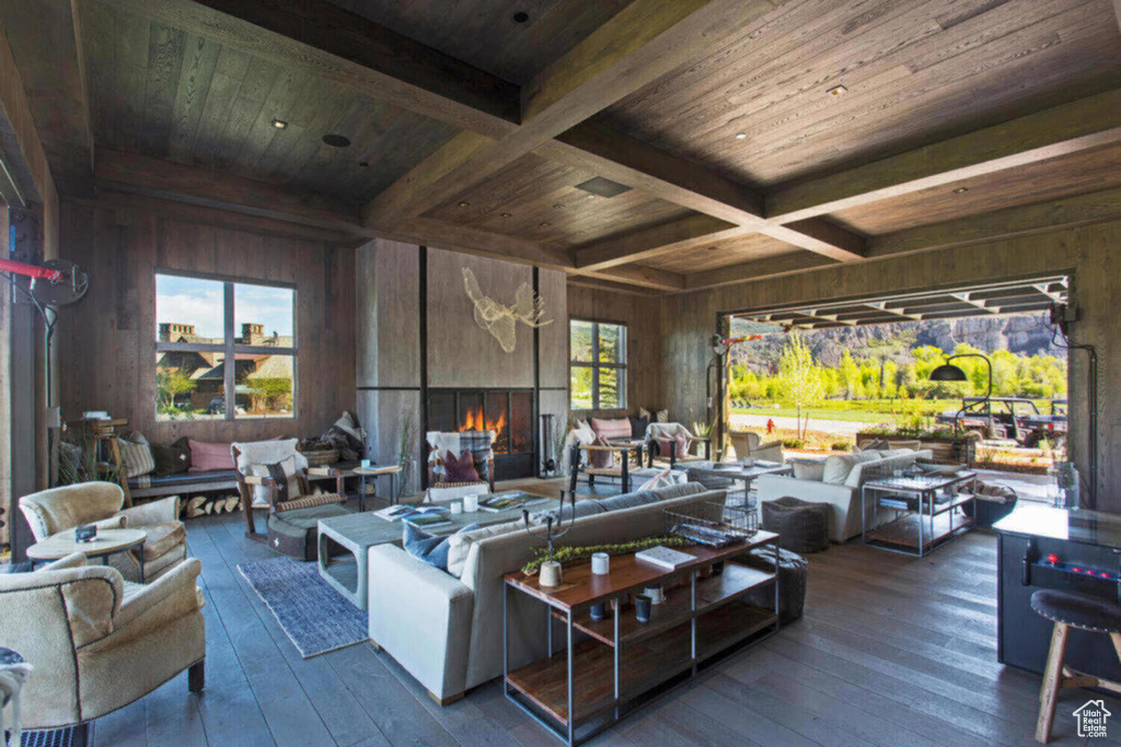 Living room featuring wood ceiling, wood-type flooring, beamed ceiling, and wood walls