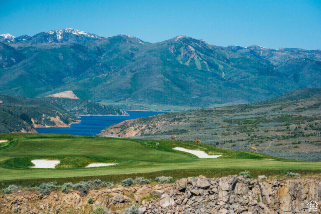 Property view of mountains with a water view and golf course view