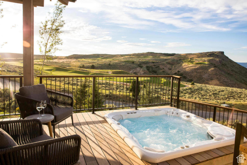Wooden deck featuring hot tub deck surround and a mountain view