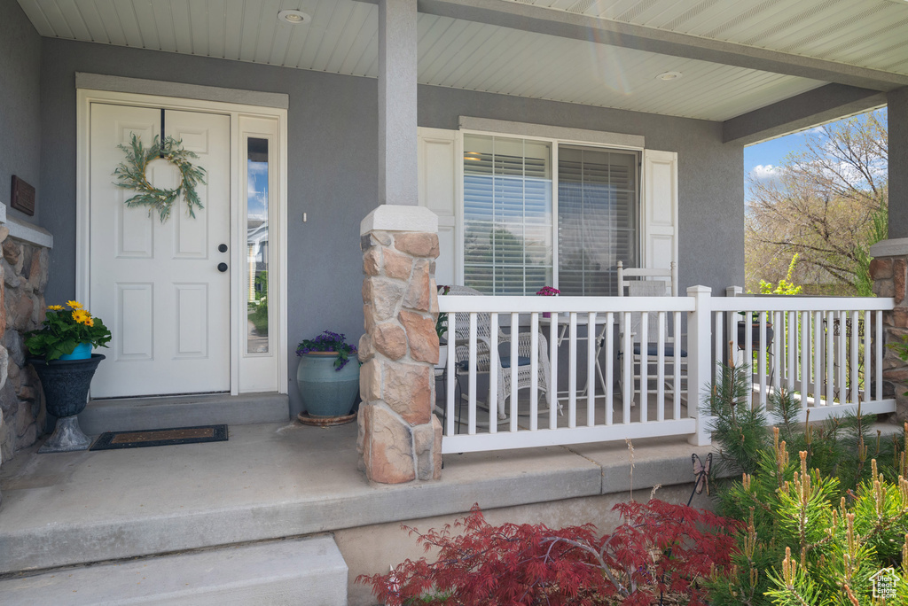 Entrance to property with a porch and stucco siding