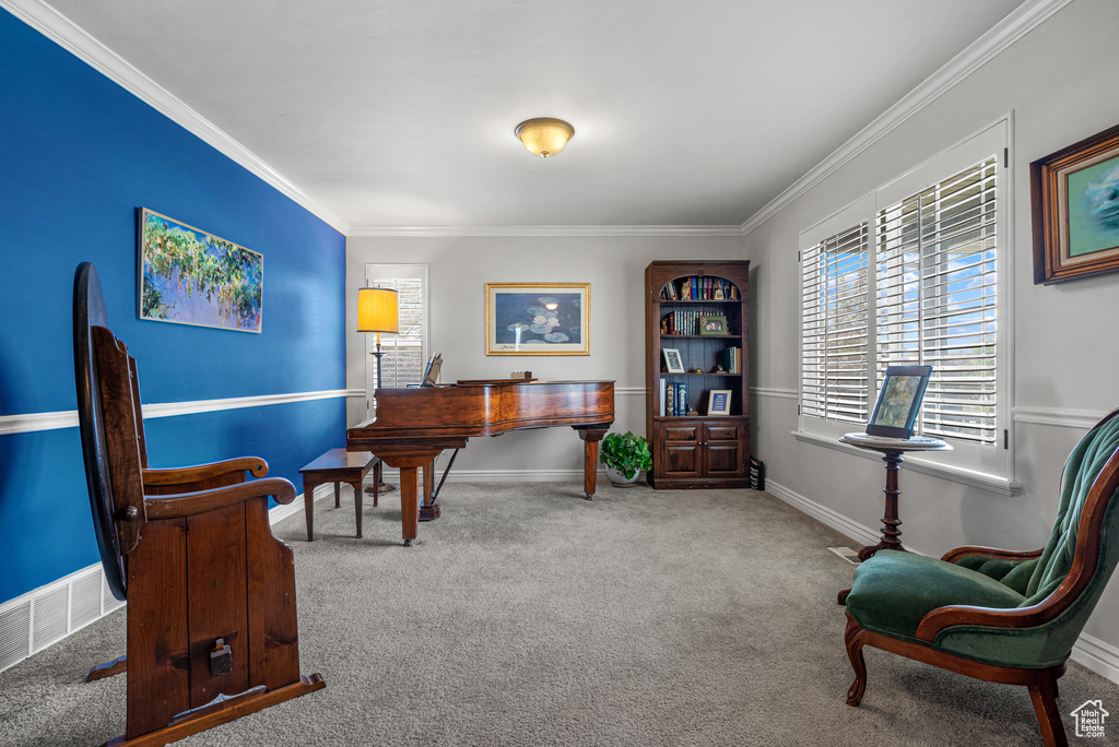 Living area with crown molding, baseboards, and carpet