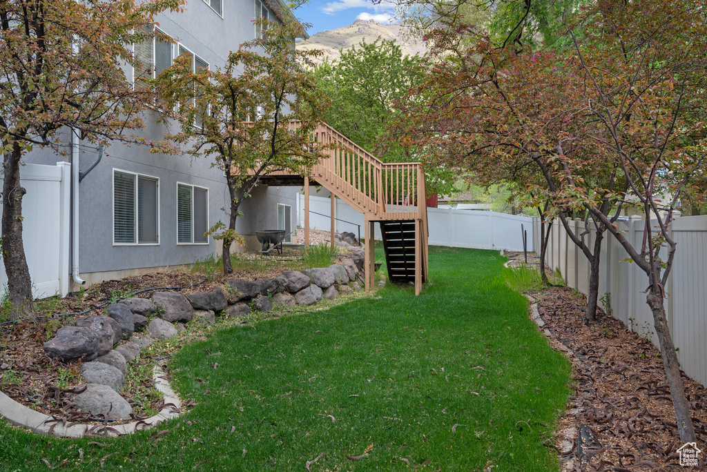View of yard featuring a fenced backyard, stairway, and a deck