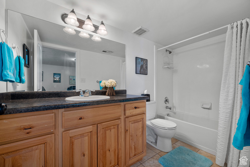 Full bath with visible vents, tile patterned flooring, vanity, toilet, and shower / tub combo with curtain