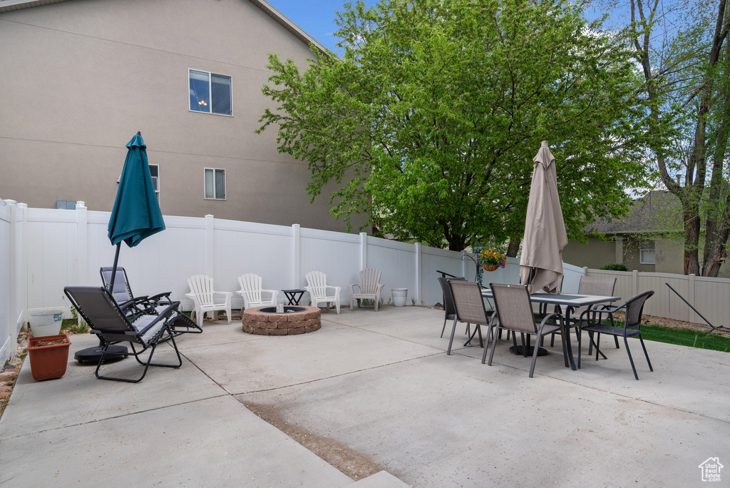 View of patio featuring a fenced backyard, outdoor dining space, and an outdoor fire pit