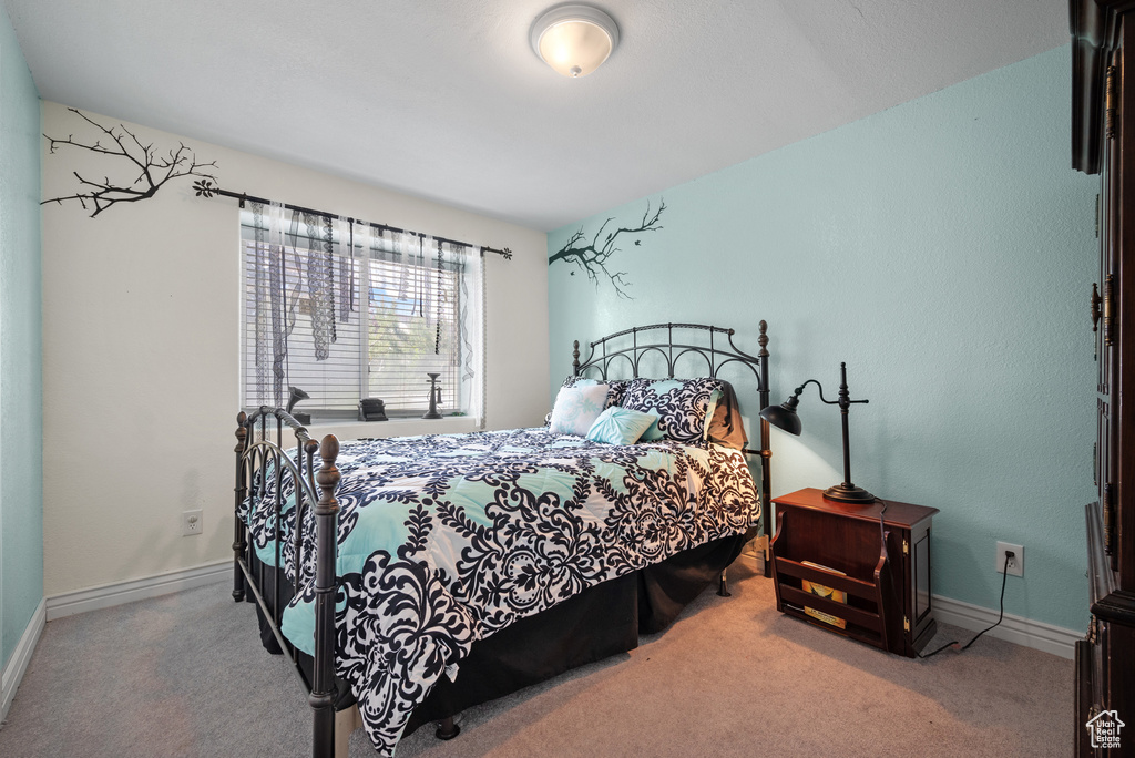 Bedroom featuring carpet floors and baseboards