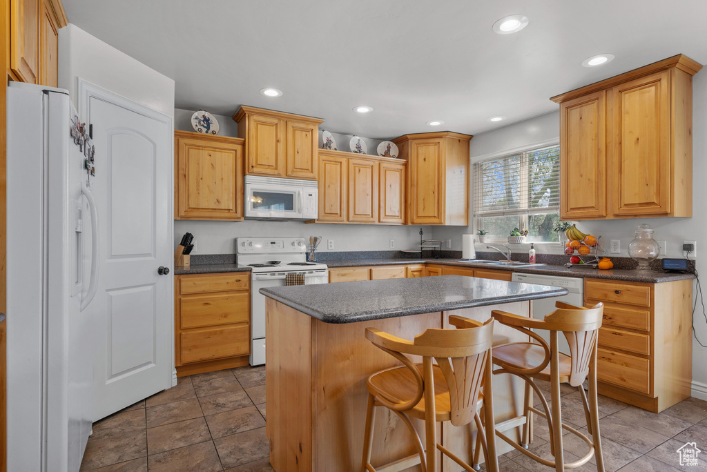 Kitchen with a sink, recessed lighting, a center island, and white appliances