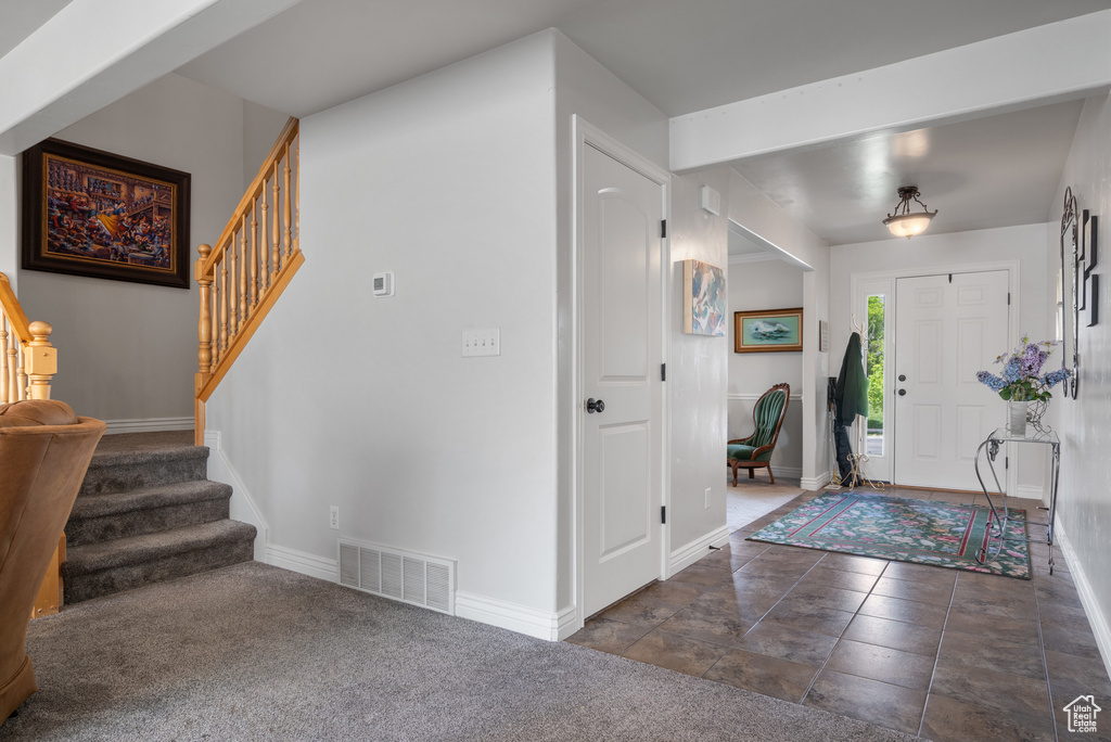 Foyer entrance featuring baseboards, stairs, and visible vents
