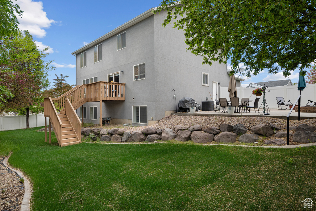 Back of house featuring a deck, stairway, fence, a yard, and a patio
