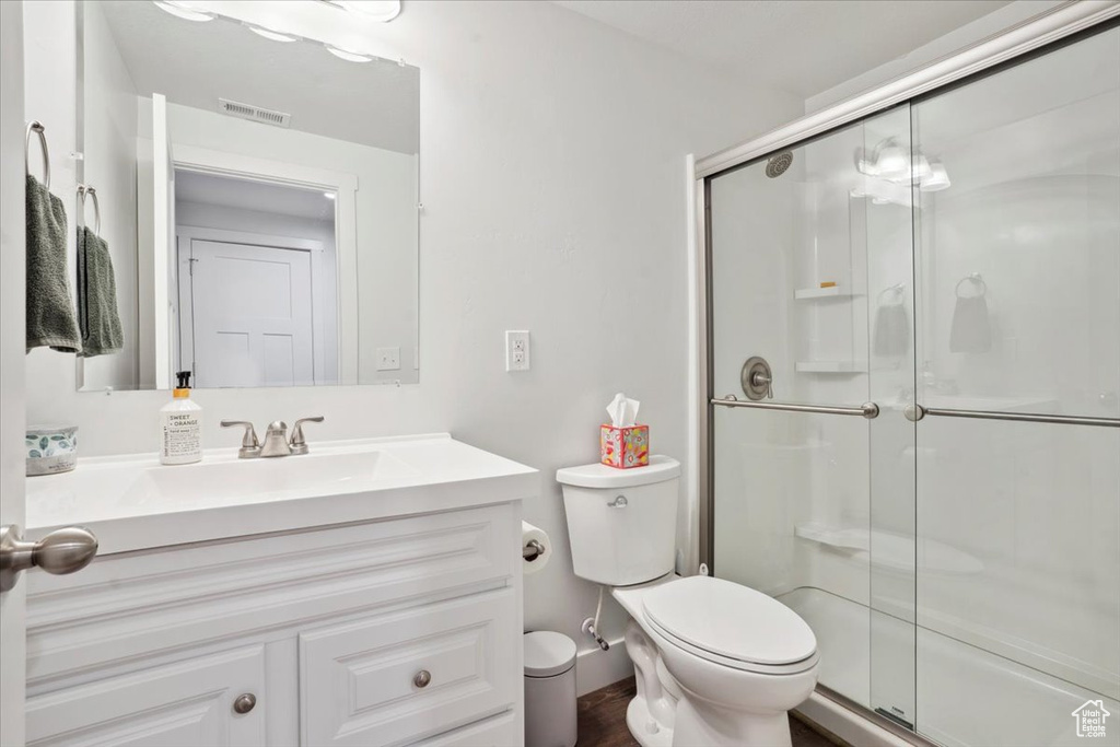 Full bathroom featuring a stall shower, toilet, and visible vents