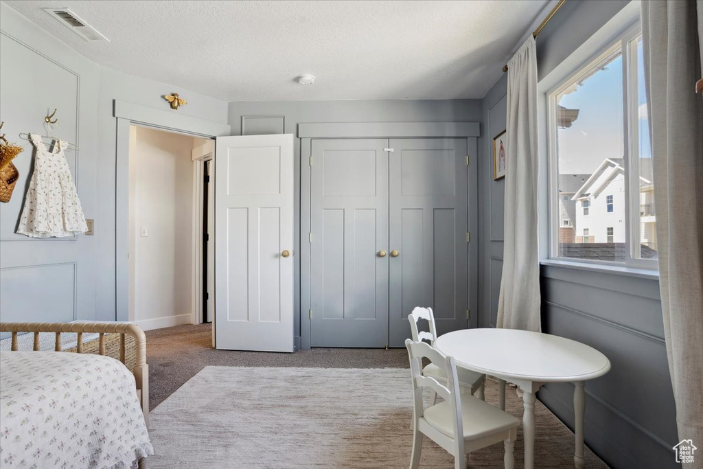 Carpeted bedroom featuring a closet and visible vents