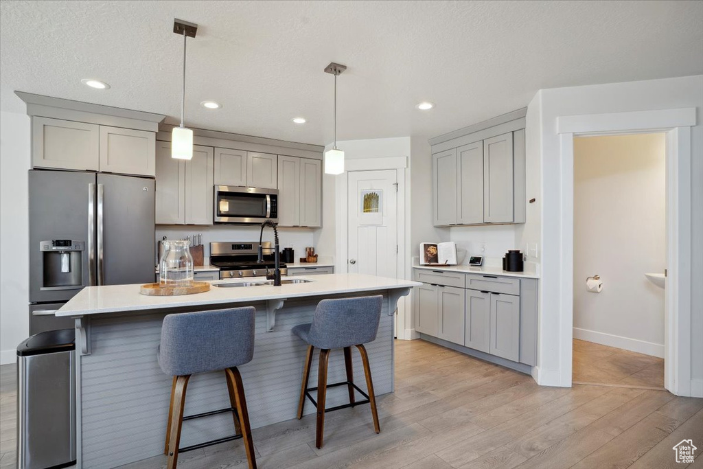 Kitchen featuring gray cabinetry, appliances with stainless steel finishes, and baseboards