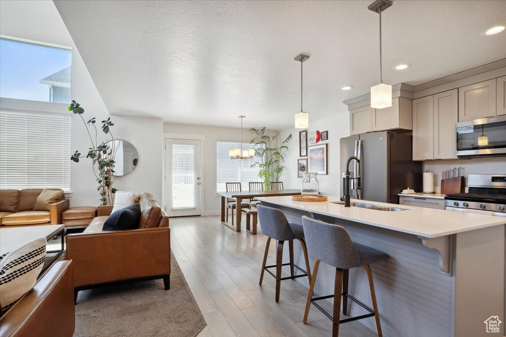 Kitchen featuring light countertops, a wealth of natural light, a breakfast bar, and stainless steel appliances