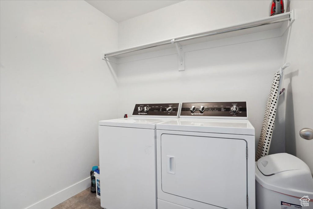 Clothes washing area featuring laundry area, baseboards, and washing machine and dryer