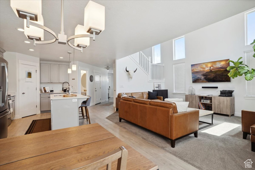 Living area with light wood-style floors, recessed lighting, and a chandelier