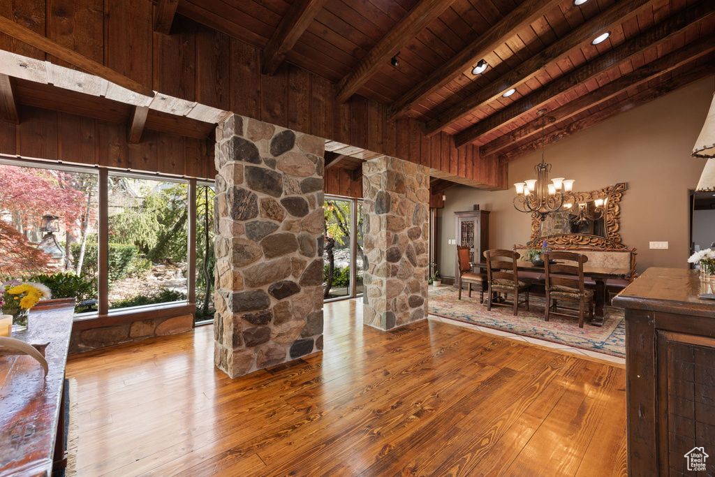 Living room with wood-type flooring, lofted ceiling with beams, a chandelier, and wooden ceiling