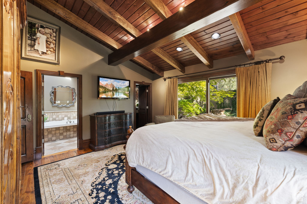 Bedroom with wood ceiling, lofted ceiling with beams, ensuite bath, and wood finished floors