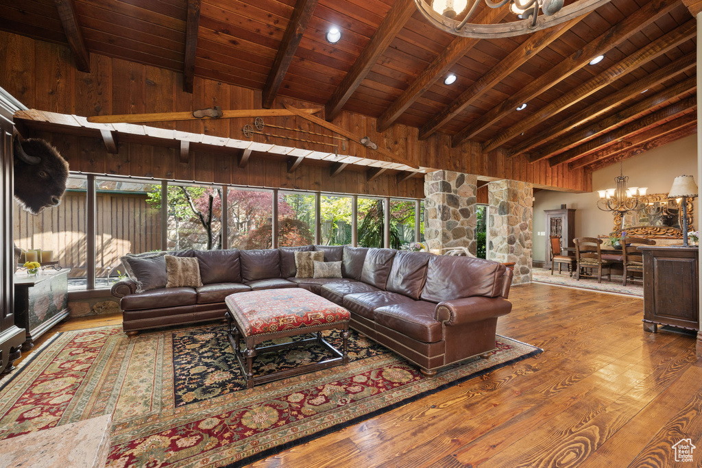 Living area featuring an inviting chandelier, wood ceiling, vaulted ceiling with beams, and wood finished floors
