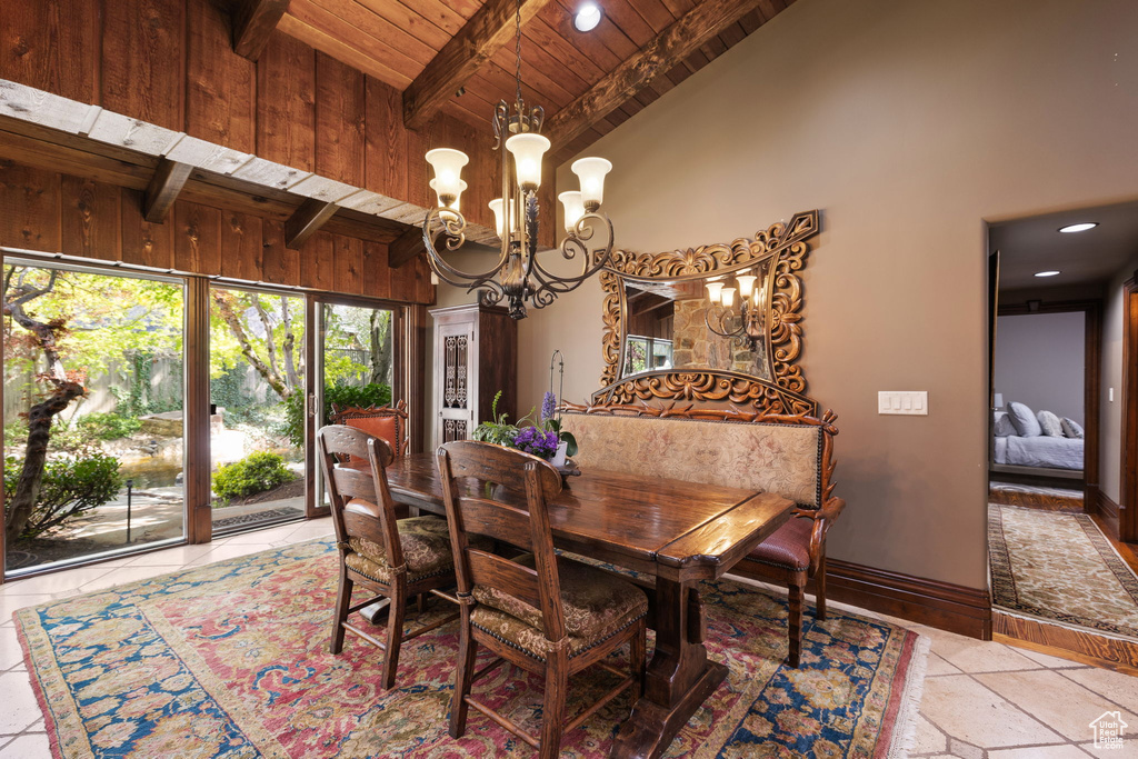 Dining space with wood ceiling, beam ceiling, baseboards, high vaulted ceiling, and a notable chandelier