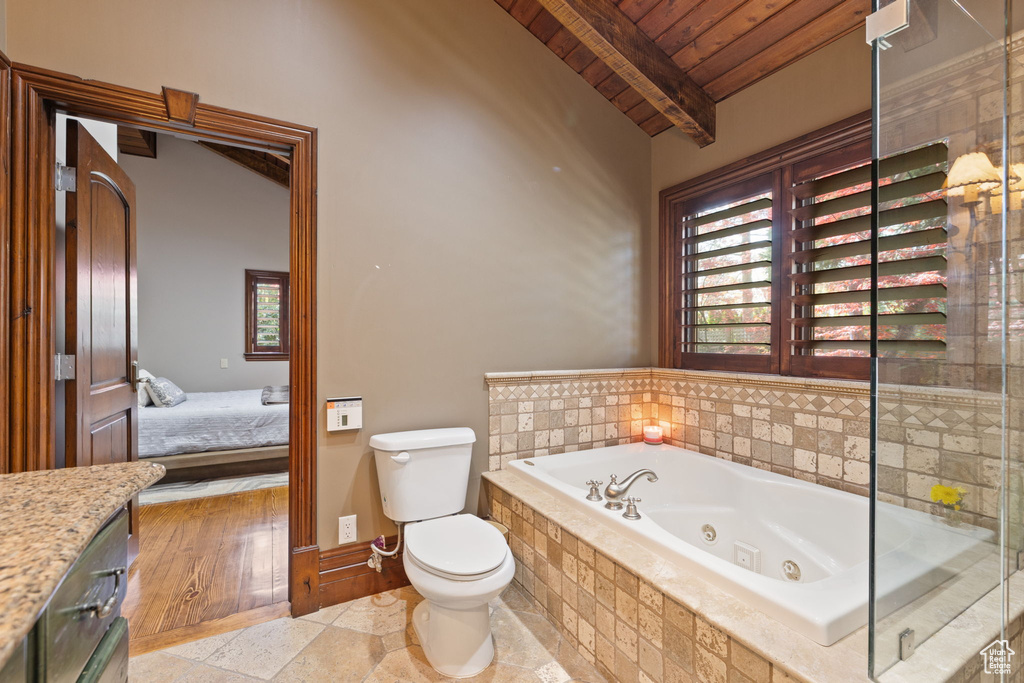 Bathroom featuring connected bathroom, beam ceiling, toilet, a jetted tub, and wood ceiling