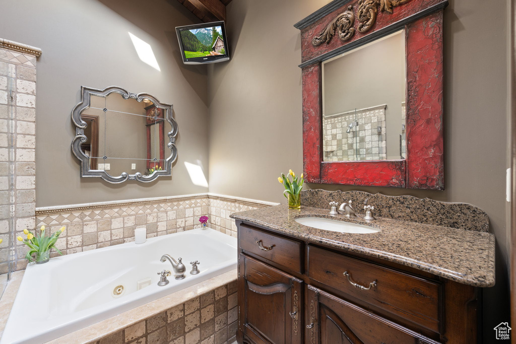 Full bathroom with vanity and a whirlpool tub