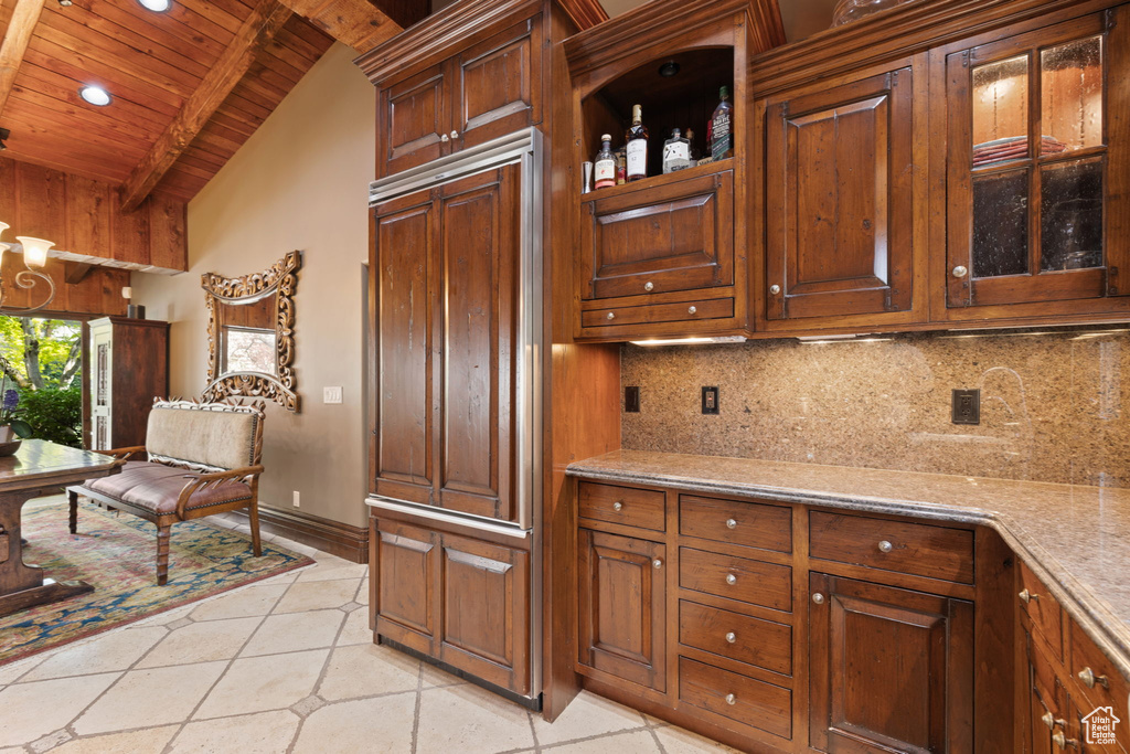 Kitchen with glass insert cabinets, vaulted ceiling with beams, recessed lighting, wood ceiling, and tasteful backsplash