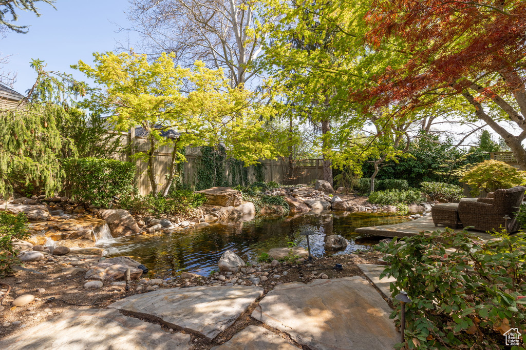 View of yard featuring fence and a small pond