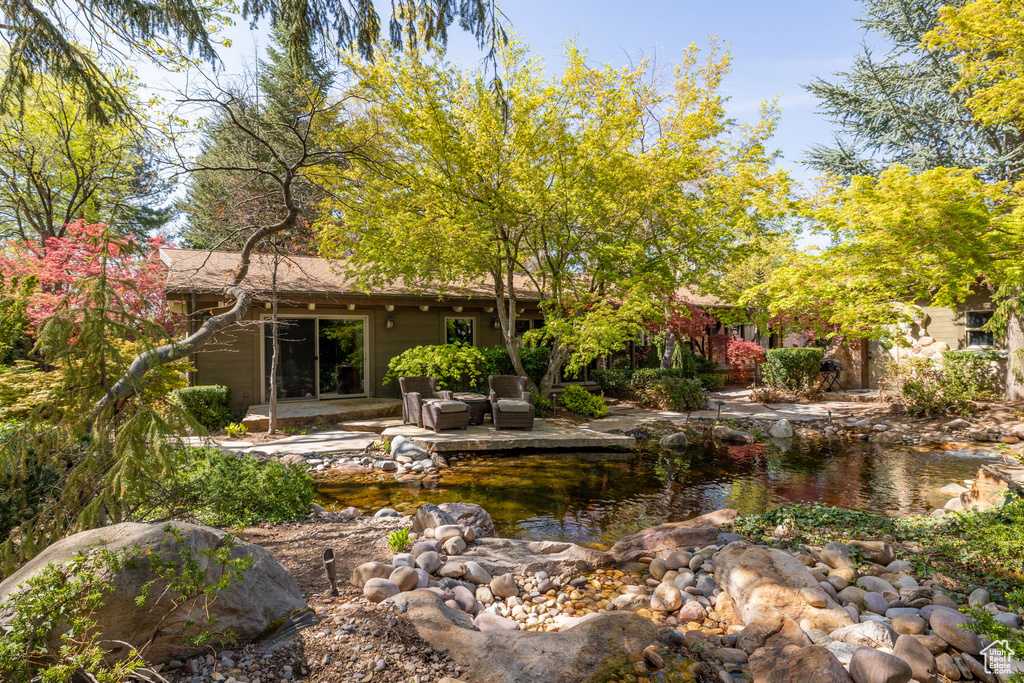 Rear view of property with a garden pond and a patio area