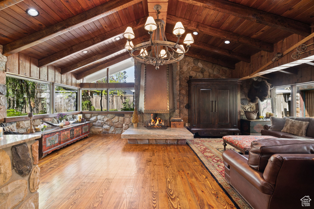 Living room featuring beam ceiling, wooden ceiling, high vaulted ceiling, a notable chandelier, and hardwood / wood-style floors