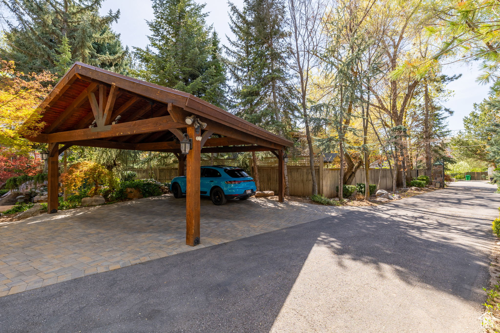 View of car parking featuring fence and a carport