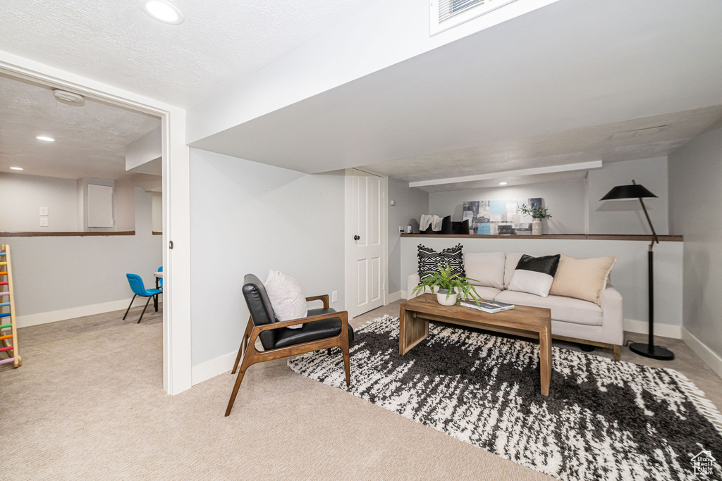 Living area with a textured ceiling, visible vents, carpet floors, baseboards, and recessed lighting