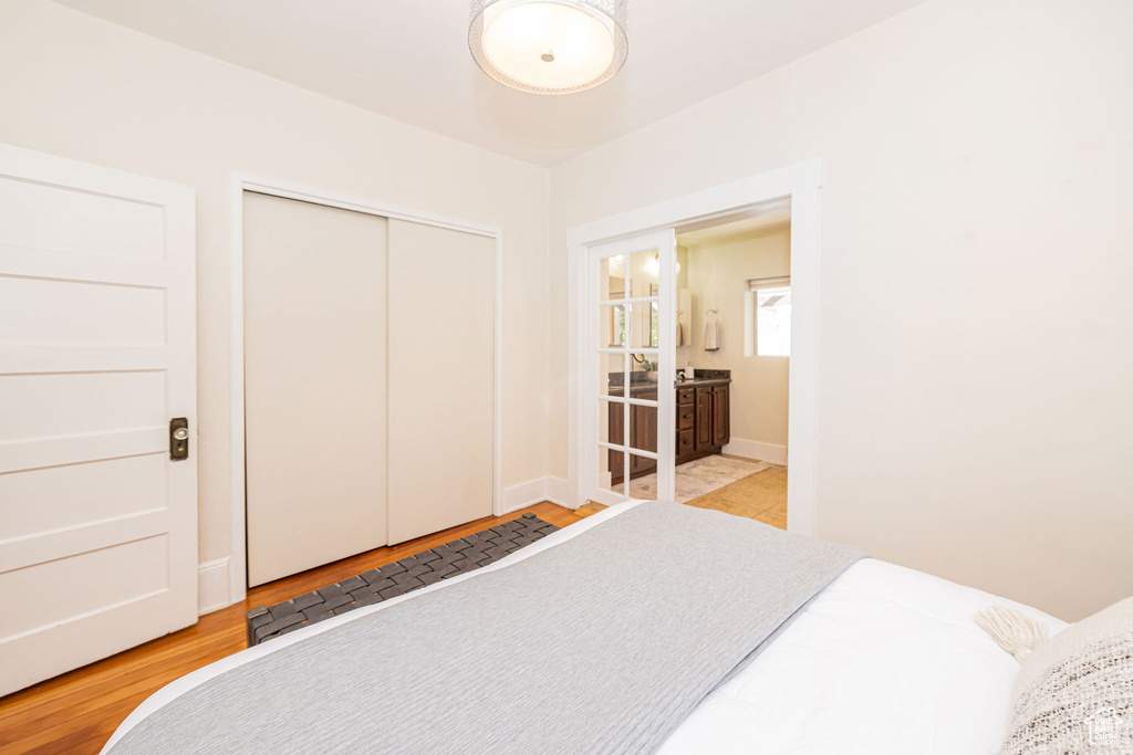 Bedroom with baseboards, a closet, and wood finished floors