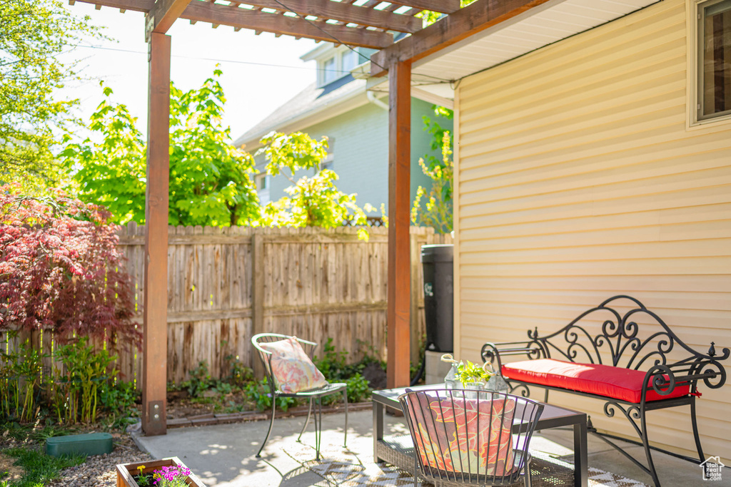 View of patio featuring outdoor dining area, fence, and a pergola