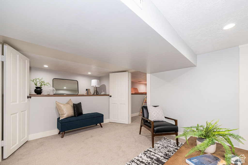 Living area with baseboards, recessed lighting, and light colored carpet
