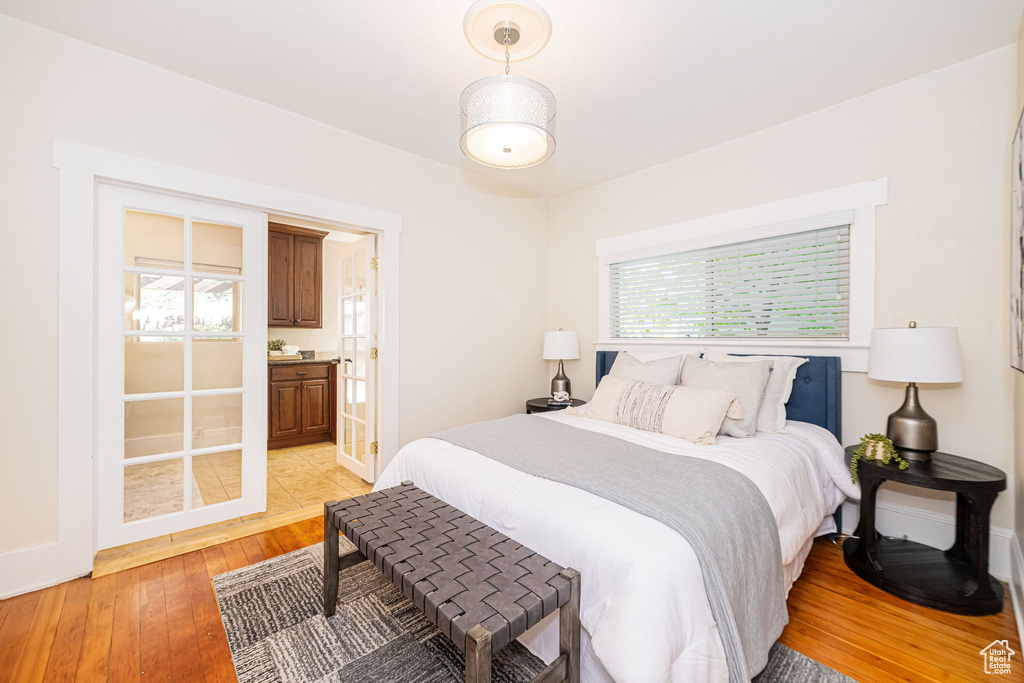 Bedroom with light wood-type flooring, baseboards, and ensuite bath