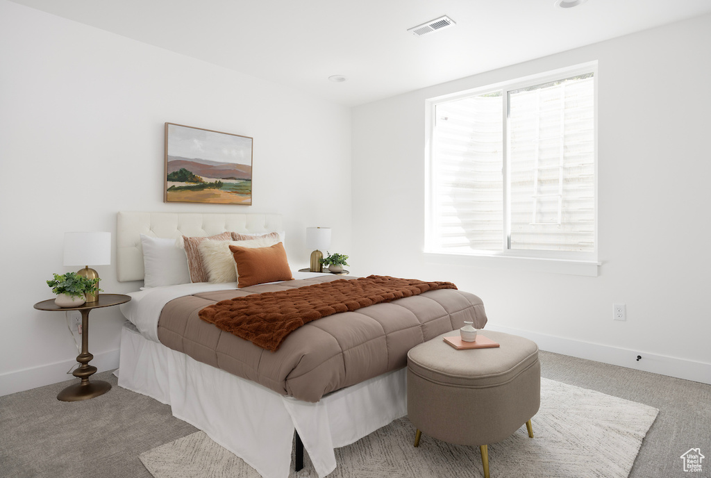 Bedroom with carpet floors, baseboards, and visible vents