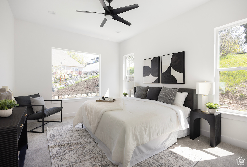 Carpeted bedroom with baseboards and a ceiling fan