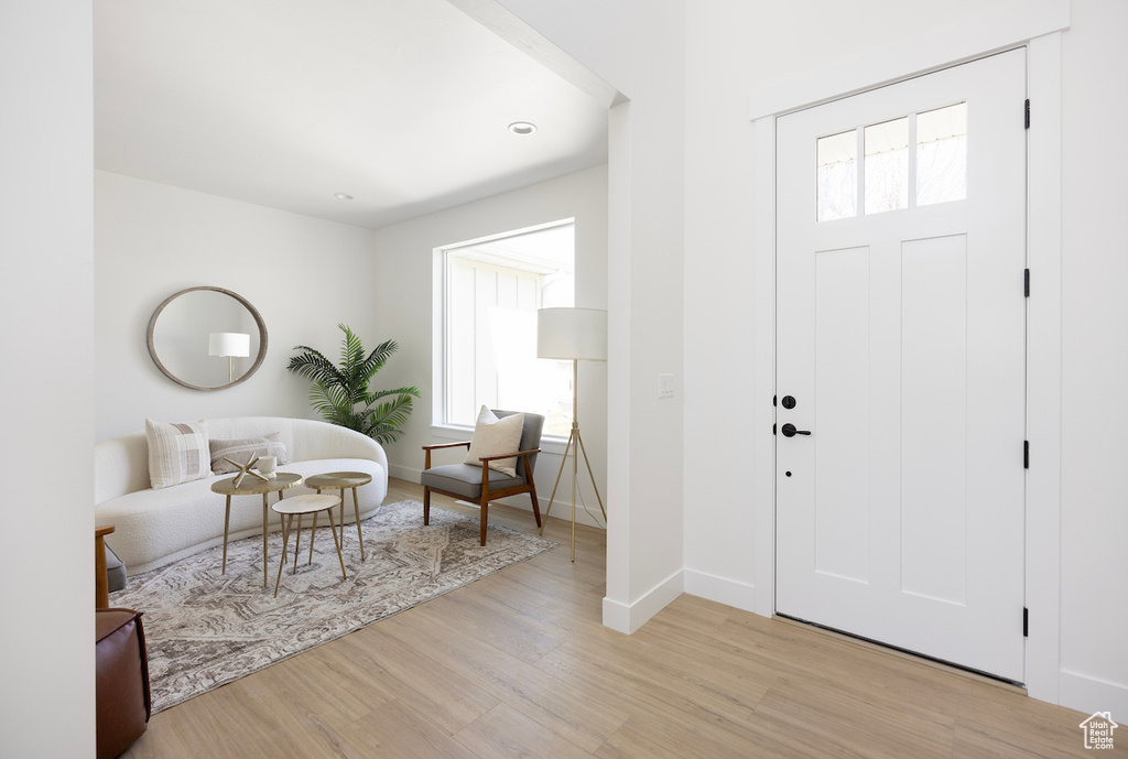 Entryway with baseboards and light wood finished floors
