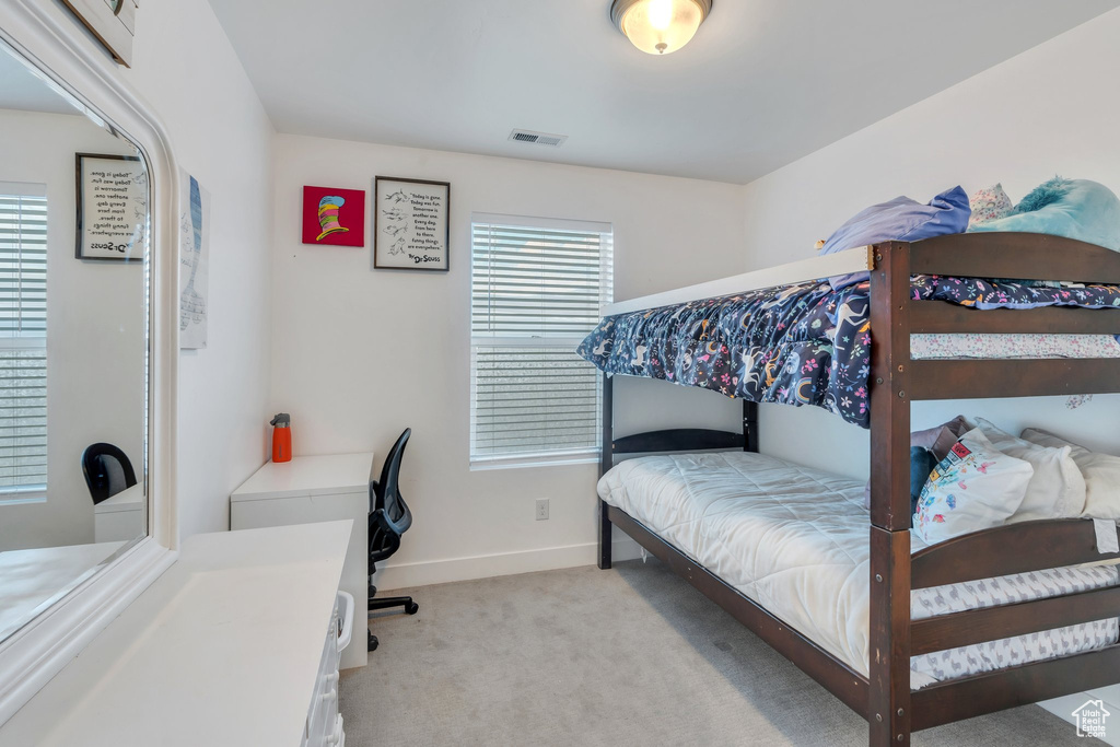 Bedroom featuring baseboards, light colored carpet, and visible vents