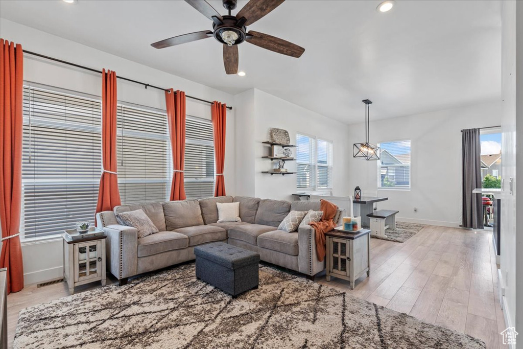 Living area with a ceiling fan, light wood-style flooring, and recessed lighting