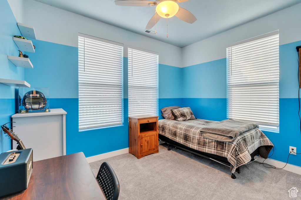 Carpeted bedroom featuring baseboards, a ceiling fan, and visible vents